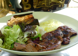 Marinated grilled turkey chops garnished with roasted eggplant, salad and  potatoes purée