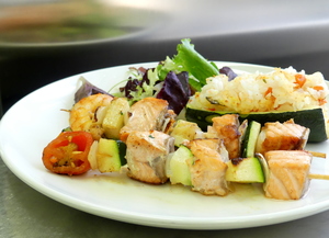 Brocheta de salmón con ensalada y calabacín relleno de arroz  y verduras