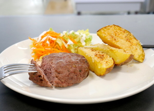 Beefburger with baked potato and "coleslaw" salad
