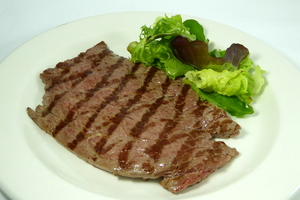 Grilled veal steak with lettuce salad