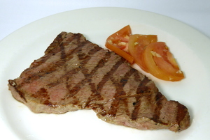 Filete a la parrilla con ensalada de tomate con ajo