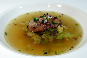 Consommé with a garnish of roasted foie gras and cabbage