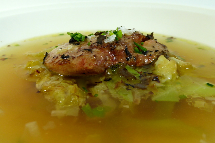 Consommé with a garnish of roasted foie gras and cabbage