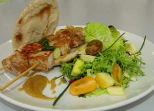 Skewers of pork tenderloin in pitta bread with salad