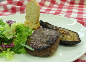 Grilled hamburger with salad, roasted aubergine and hummus